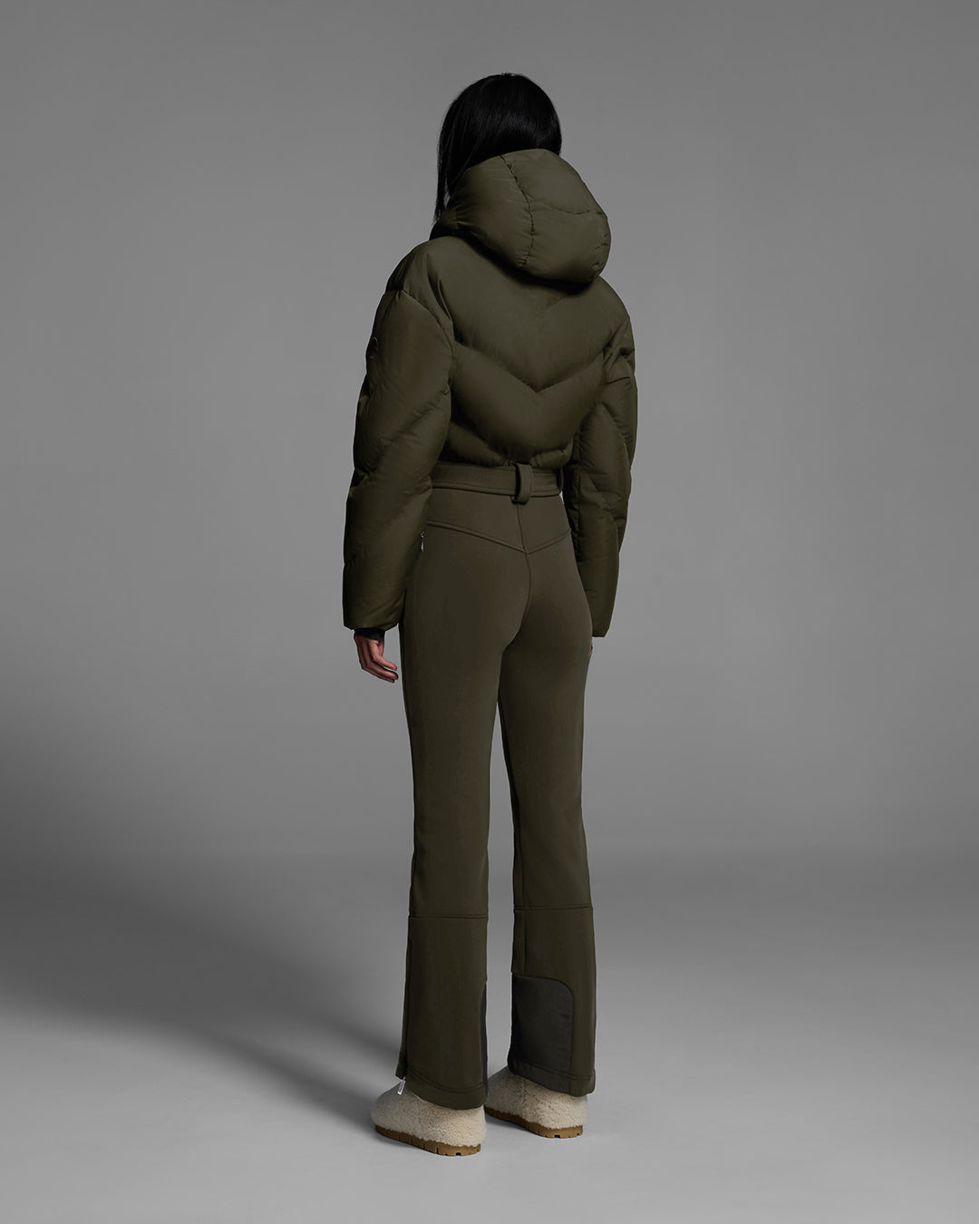 Back view of a female model wearing a belted khaki green color ski suit with down filled top and 4-way stretch bottom. #color_khaki