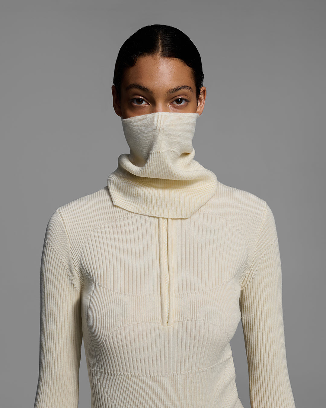 Detail front view of a female model wearing a knit wool buff in alabaster white with matching bodysuit. #color_alabaster