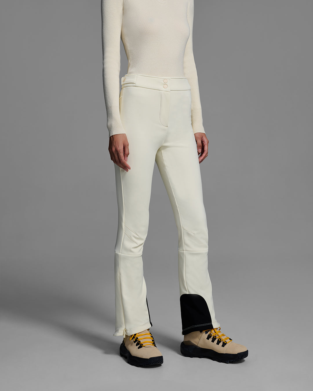 Woman wearing a 4-way stretch ski pant in alabaster white and a matching ski sweater. #color_alabaster