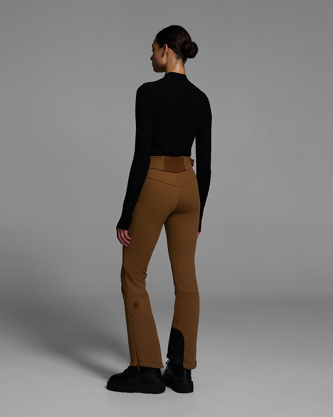 Back view of a woman wearing a 4-way stretch ski pant in sepia brown and a black base layer top. #color_sepia