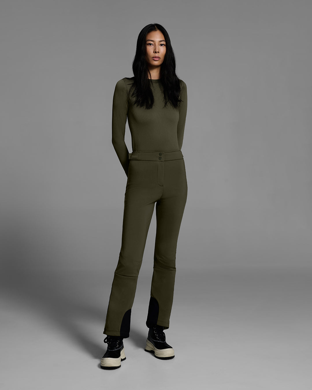 Woman wearing a 4-way stretch ski pant in khaki green with a matching base layer top. #color_khaki