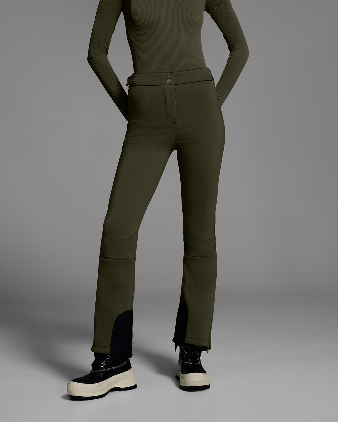 Detail pant view of a Woman wearing a 4-way stretch ski pant in khaki green with a matching base layer top. #color_khaki