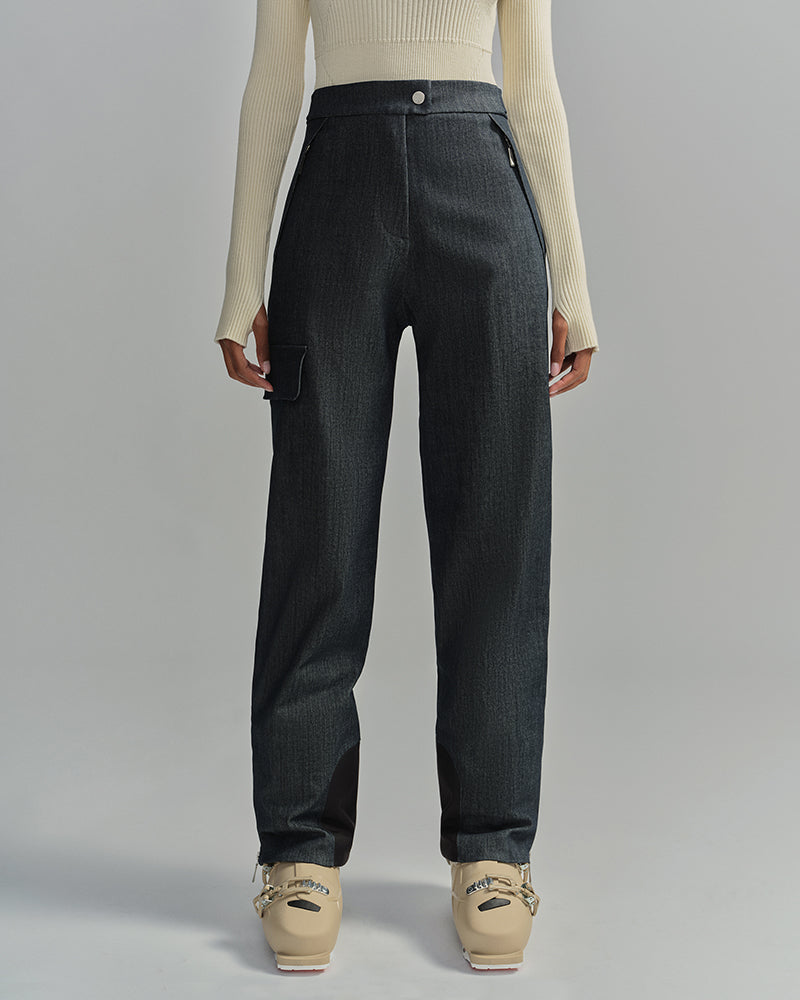 Detail shot of model wearing denim skiing pants with a cream sweater and cream ski boots #color_denim