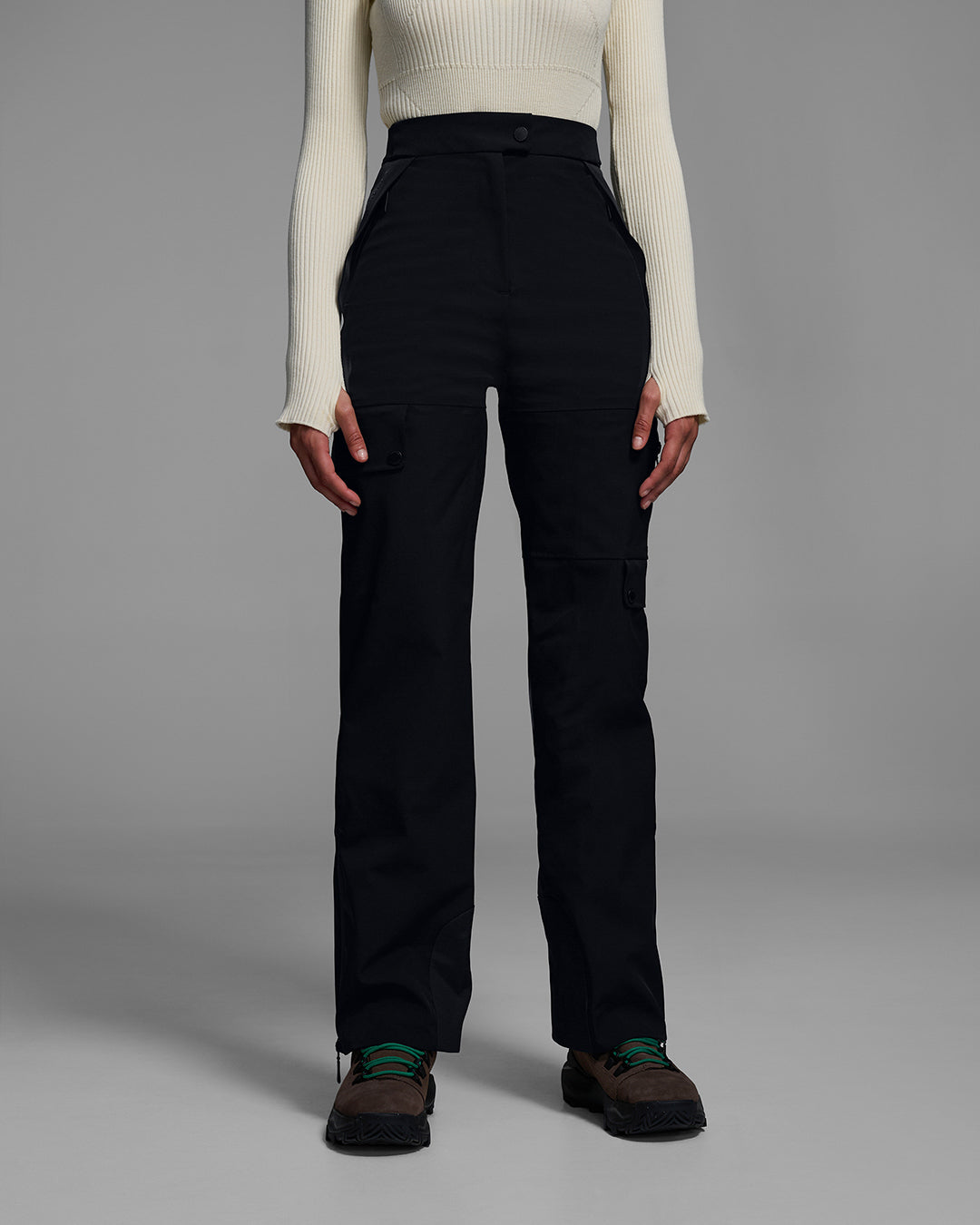Front detail view of a woman wearing technical ski pants in black with white ski sweater top. #color_onyx