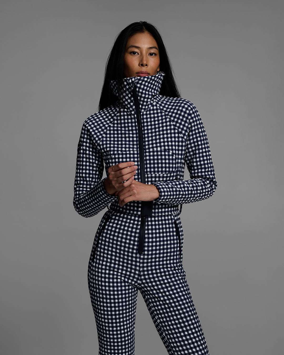Detail view of a female model wearing a belted indigo blue and white gingham print ski suit #color_indigo gingham