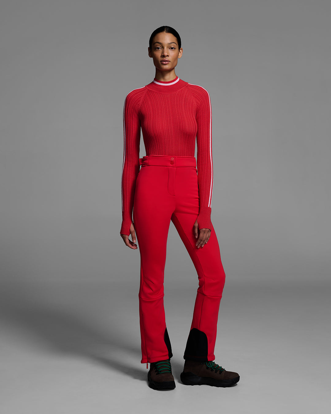 Woman wearing a 4-way stretch ski pant in poppy red and a matching red ski sweater. #color_poppy