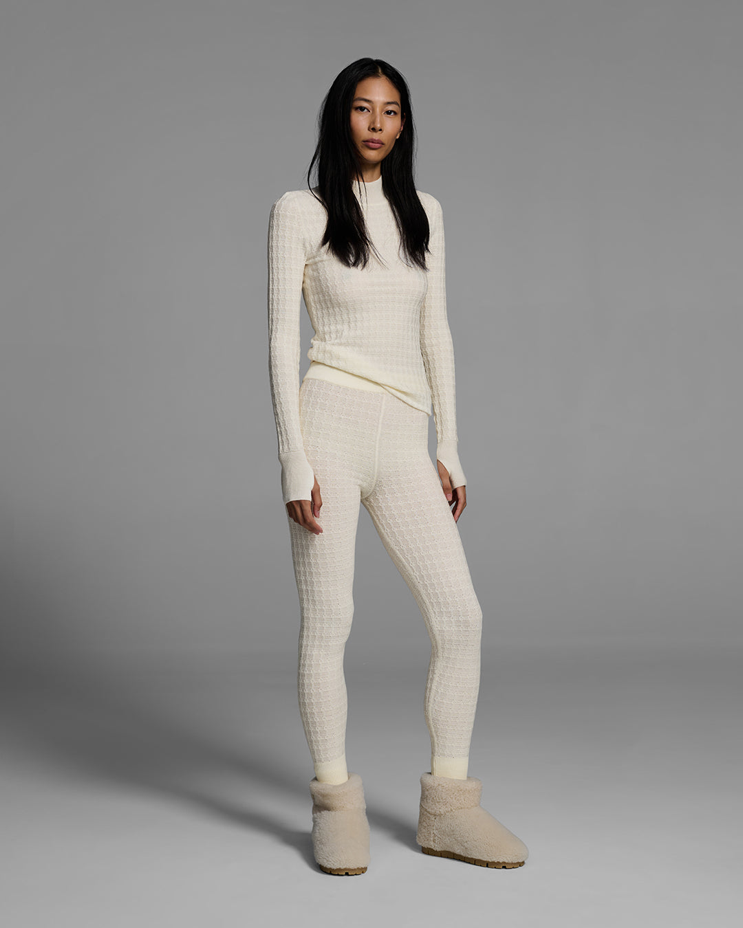 Woman wearing a textural knit base layer top and bottom in off-white. #color_alabaster